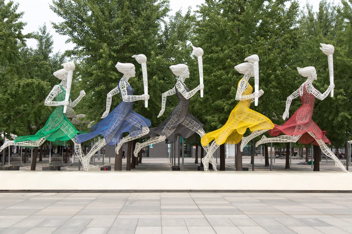 Sculpture of running figures in the colours of the Olympic rings