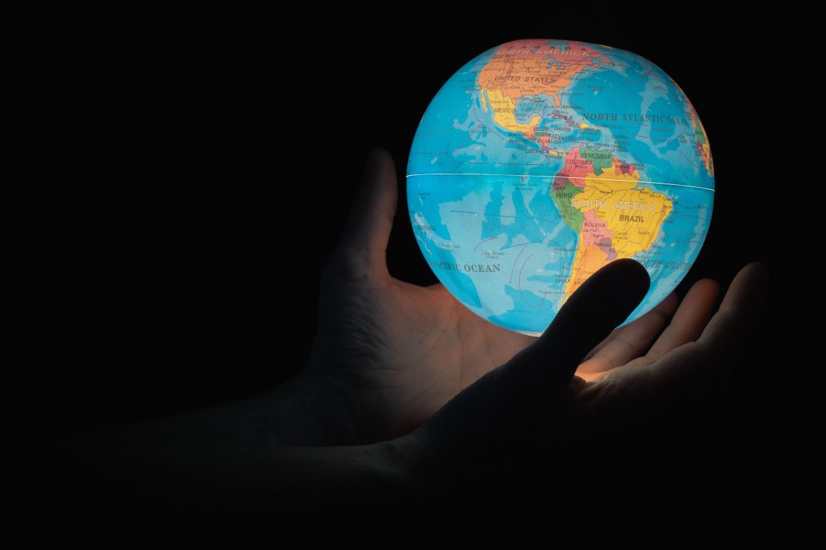 Hands holding a glowing globe
